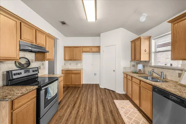 a bedroom with a bed rug and wooden floor