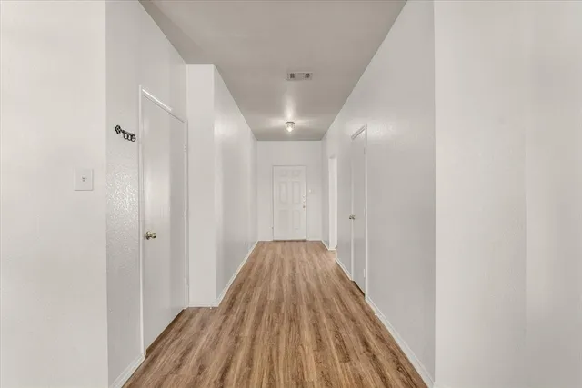 a view of a hallway with wooden floor
