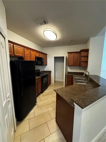 a kitchen with granite countertop a refrigerator and a sink