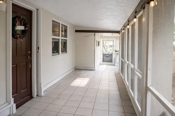 a hallway with a black white checkered floor and next to a window