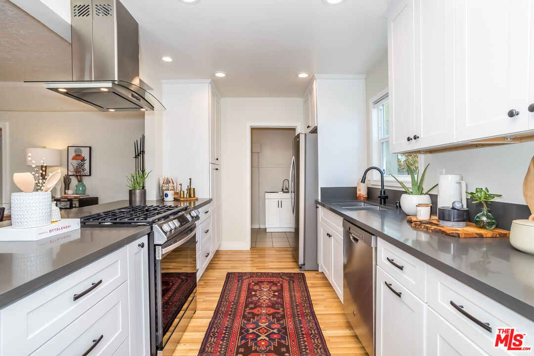 2850 Buckingham Road Los Angeles, CA 90016 - Photo 16 of 34 a kitchen with stainless steel appliances a sink stove and refrigerator