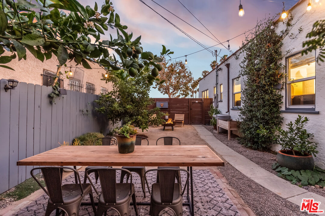 2850 Buckingham Road Los Angeles, CA 90016 - Photo 31 of 34 a view of a backyard with table and chairs potted plants and large tree
