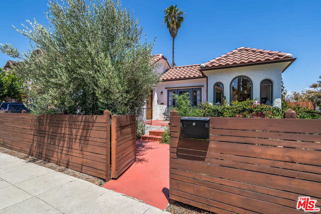 2850 Buckingham Road Los Angeles, CA 90016 - Photo 4 of 34 a front view of a house with a yard and potted plants