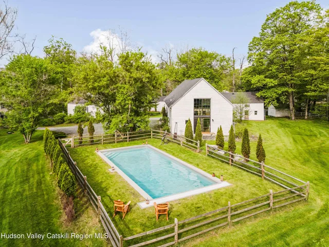 a view of a brick house with large windows and table and chairs