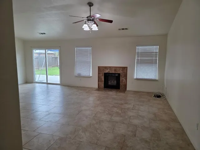 an empty room with windows and fireplace