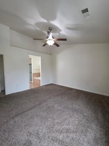 a view of a room with a ceiling fan and a window