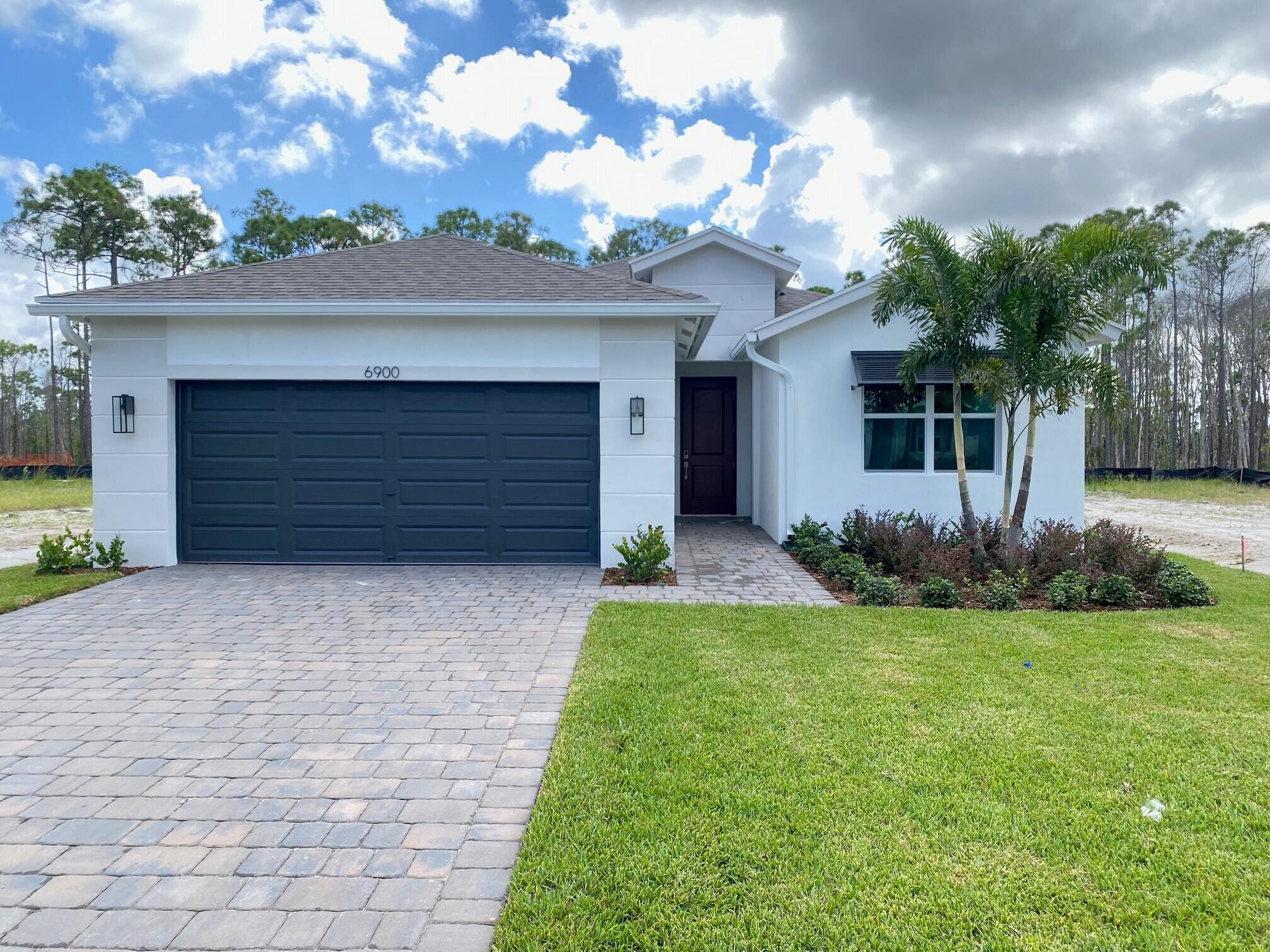 a front view of a house with a garden and garage