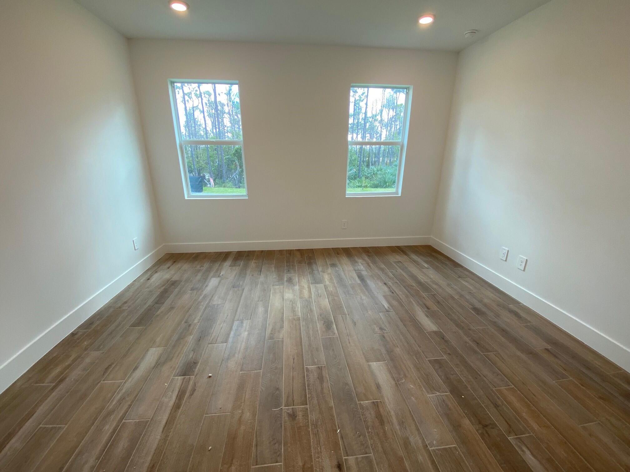 6900 Southeast Park Trace Drive Stuart, FL 34997 - Photo 11 of 14 an empty room with wooden floor and windows
