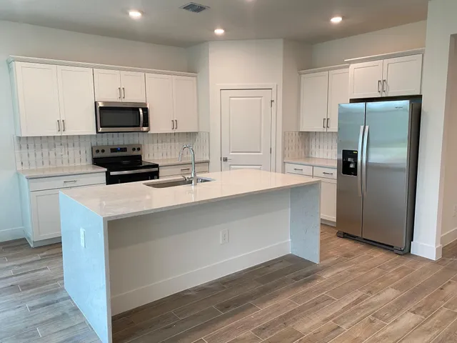 a kitchen with kitchen island a sink stainless steel appliances and cabinets
