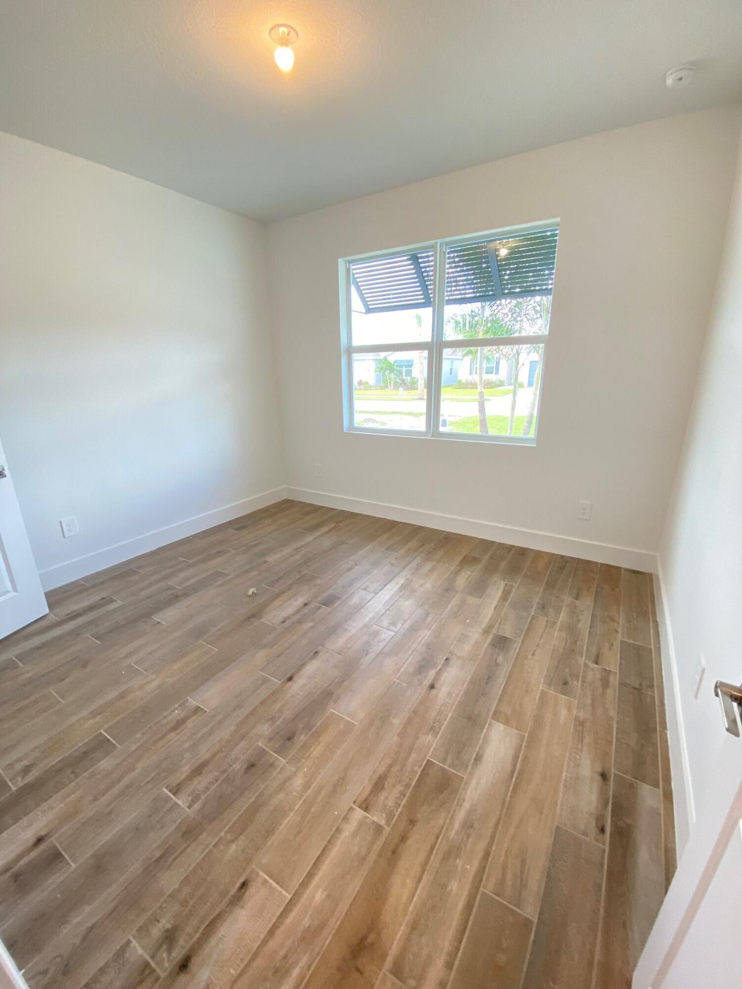 6900 Southeast Park Trace Drive Stuart, FL 34997 - Photo 8 of 14 an empty room with wooden floor and windows