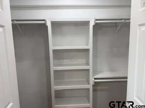 a view of walk in closet with empty racks