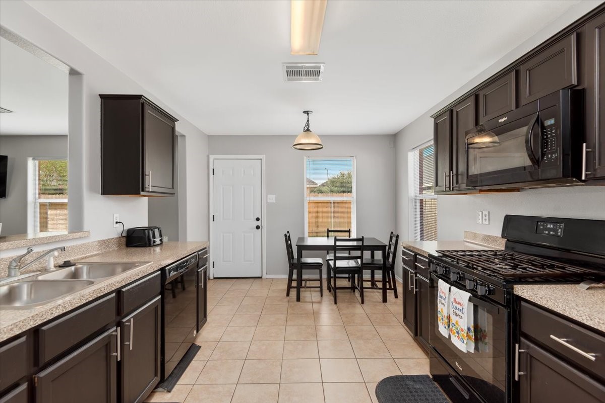 12716 Rio Lindo Street Rosharon, TX 77583 - Photo 9 of 17 a kitchen with stainless steel appliances granite countertop a sink stove and cabinets