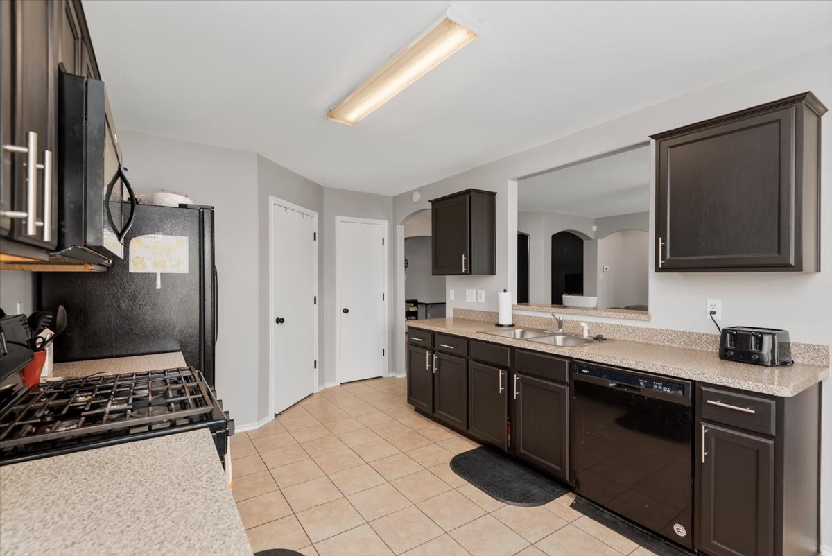 12716 Rio Lindo Street Rosharon, TX 77583 - Photo 10 of 17 a large kitchen with stainless steel appliances granite countertop a sink and a stove