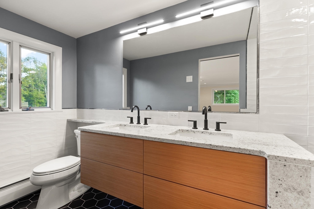 19 Selwyn Road Newton, MA 02461 - Photo 13 of 23 a bathroom with a granite countertop sink mirror vanity and toilet