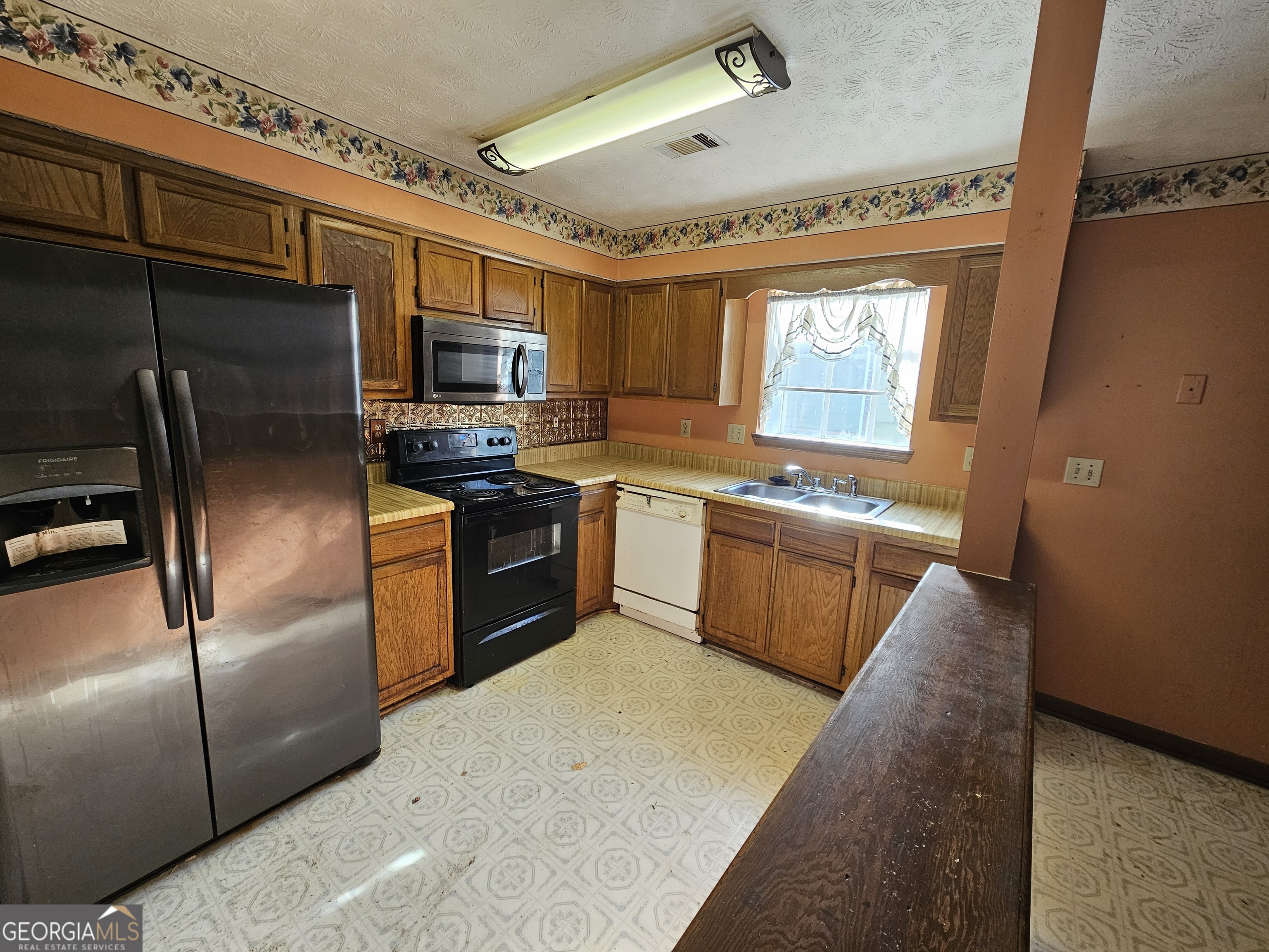1596 Bonanza Church Road Jonesboro, GA 30236 - Photo 3 of 30 a kitchen with stainless steel appliances granite countertop a stove a sink dishwasher a refrigerator and a microwave oven