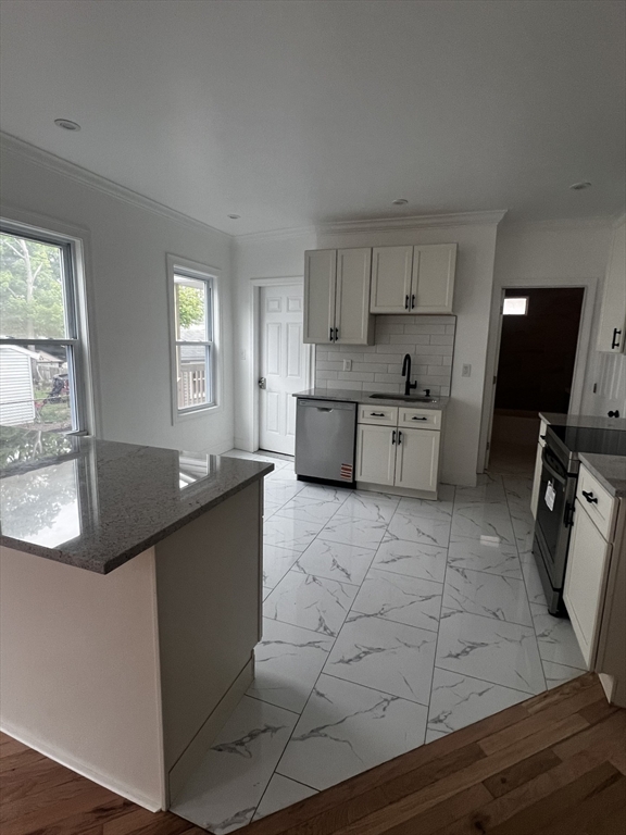 19 Reeves Street Worcester, MA 01607 - Photo 3 of 30 a kitchen with stainless steel appliances granite countertop a sink counter space and a window