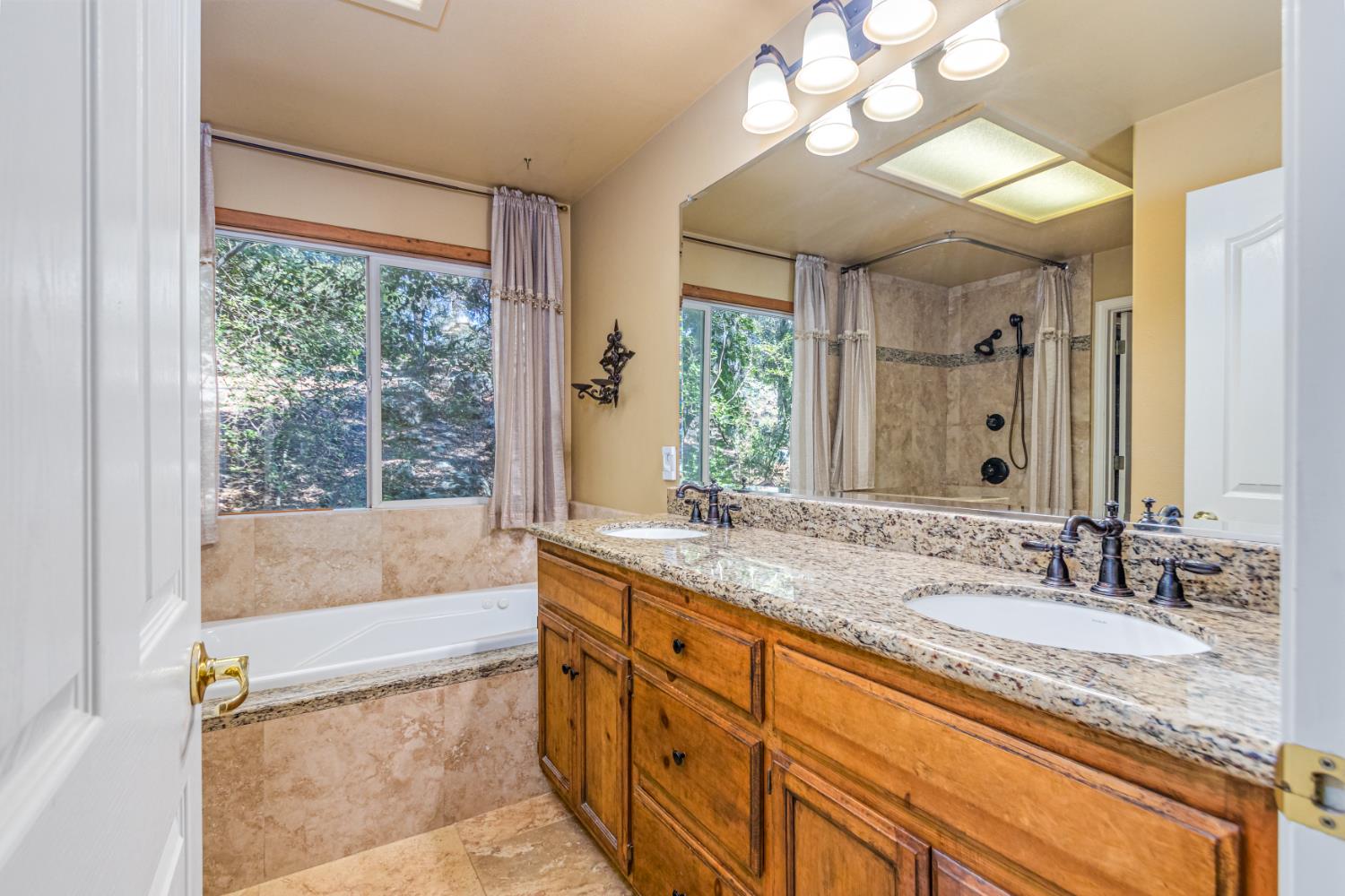 9290 Cramer Road Auburn, CA 95602 - Photo 27 of 67 a bathroom with a granite countertop tub sink vanity mirror and next to a window