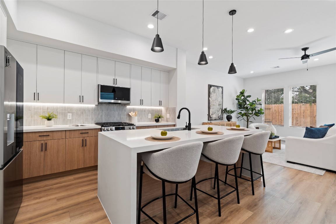 a kitchen with appliances a sink and cabinets