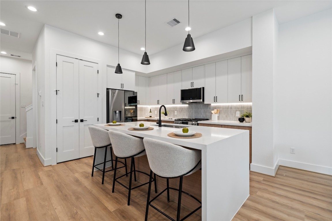 2706 Fox Street Houston, TX 77003 - Photo 4 of 39 a kitchen with stainless steel appliances a dining table chairs microwave and sink