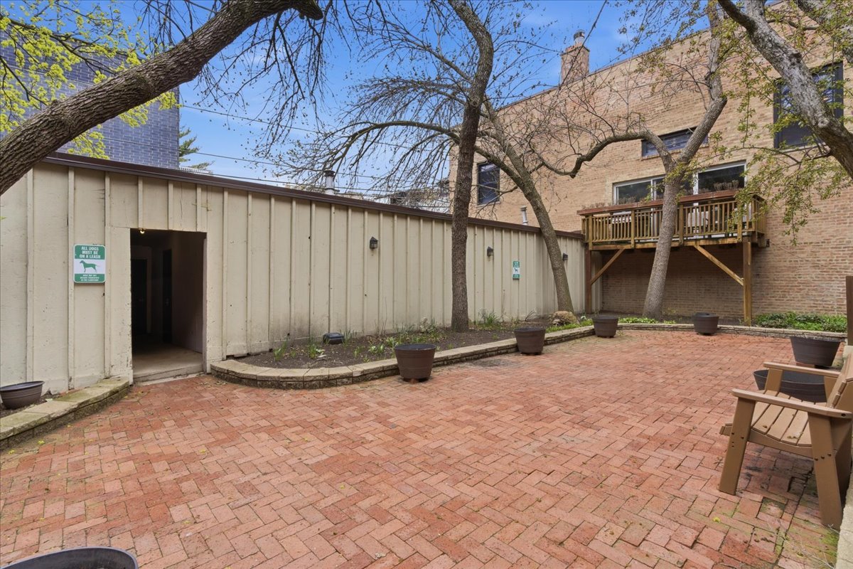 802 West George Street, Unit 1 Chicago, IL 60657 - Photo 17 of 18 a backyard of a house with barbeque oven table and chairs