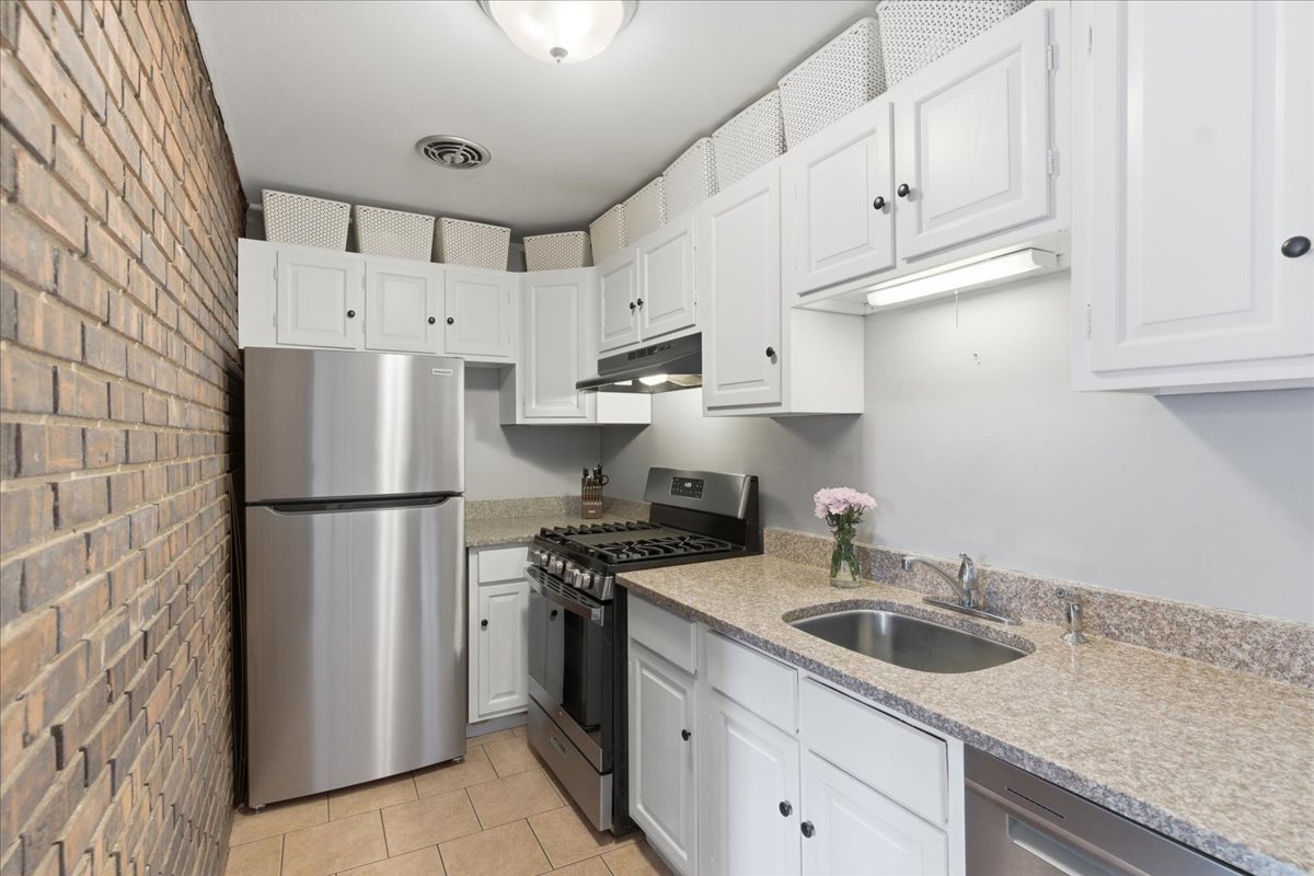 802 West George Street, Unit 1 Chicago, IL 60657 - Photo 6 of 18 a kitchen with stainless steel appliances white cabinets and a refrigerator