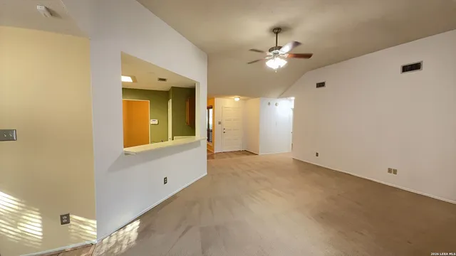a view of a livingroom with a ceiling fan and window