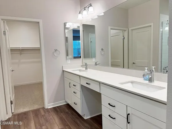 a spacious bathroom with a double vanity sink a mirror and shower