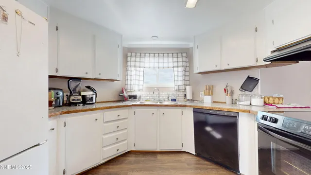 a kitchen with cabinets appliances a sink and a window