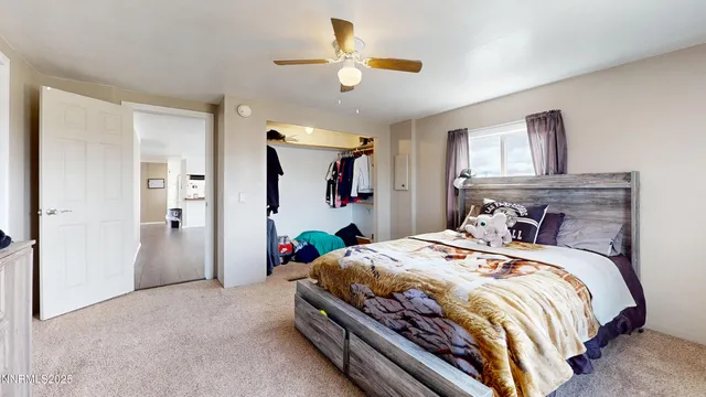 a bedroom with a bed a chandelier and a flat screen tv