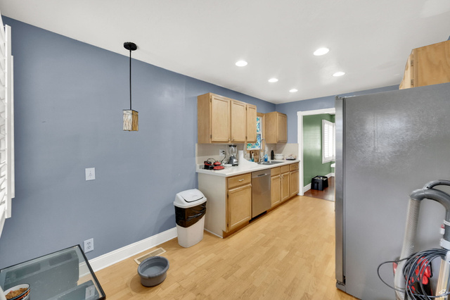 4635 Box Elder Street Murray, UT 84107 - Photo 11 of 21 Kitchen with stainless steel appliances, light wood finish cabinetry, light countertops, light wood-style flooring, and decorative light fixtures