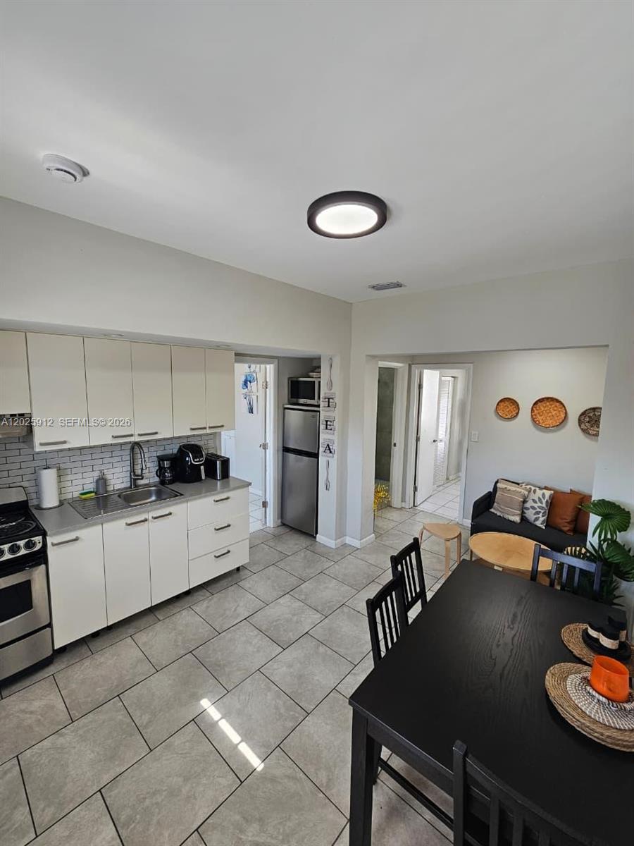 2224 Southwest 11th Street, Unit 3 Miami, FL 33135 - Photo 4 of 15 a large white kitchen with lots of appliances a sink and living room view