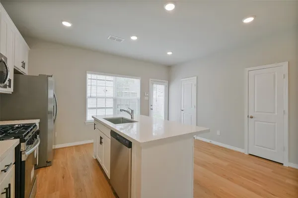 a kitchen with granite countertop a sink stove and refrigerator