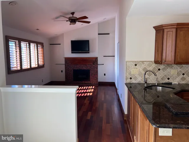 a kitchen with granite countertop a stove a sink and a microwave
