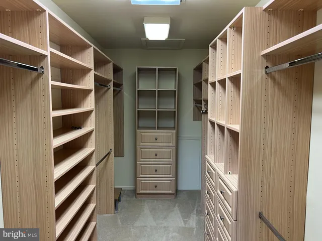 a view of walk in closet with empty racks