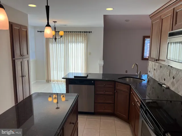 a kitchen with stainless steel appliances granite countertop a sink a stove and a refrigerator