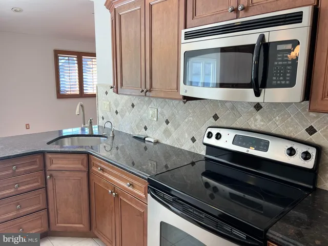 a kitchen with granite countertop a stove and a sink