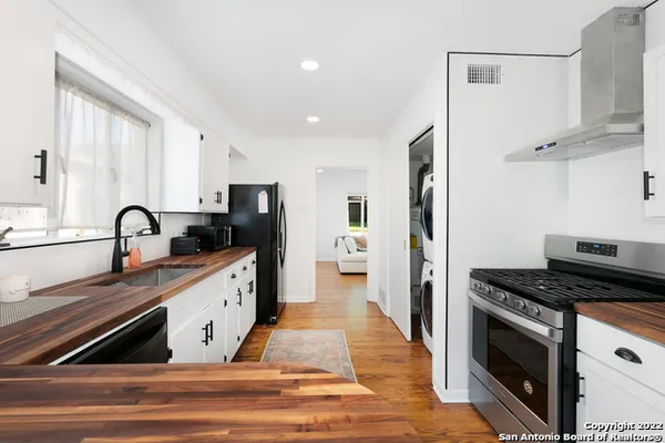 a kitchen with granite countertop a refrigerator stove and sink