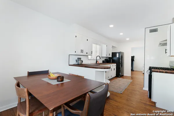 a kitchen with a dining table chairs and refrigerator