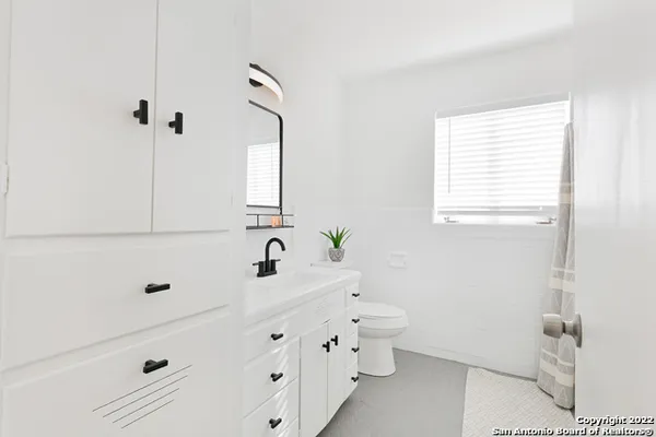 a bathroom with a double vanity sink a toilet and a mirror