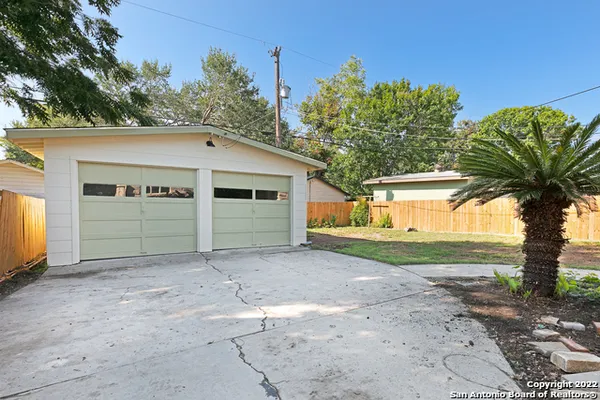 a backyard of a house with a garden and tree