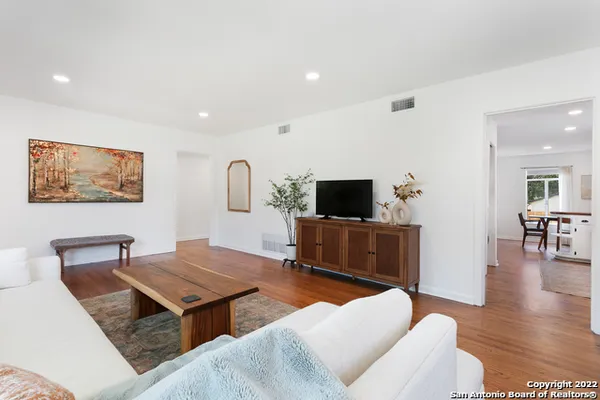 a living room with furniture a flat screen tv and a table
