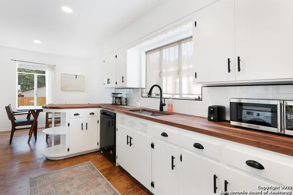a kitchen with cabinets a sink and a fireplace