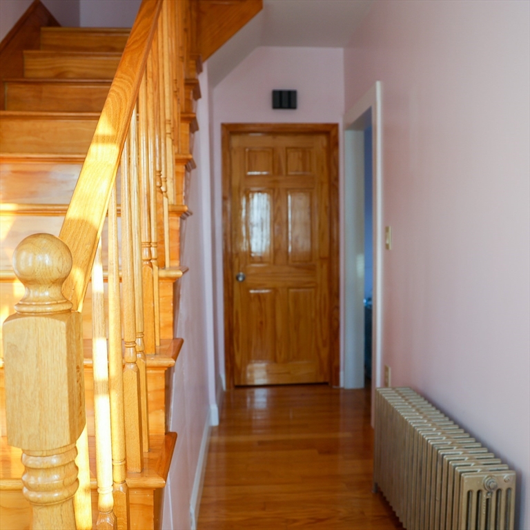 186 Powell Street Lowell, MA 01851 - Photo 11 of 42 a view of a hallway with wooden floor and door