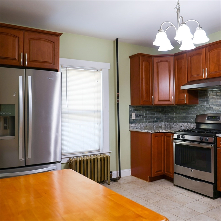 186 Powell Street Lowell, MA 01851 - Photo 17 of 42 a kitchen with stainless steel appliances granite countertop a refrigerator a sink dishwasher a stove and a microwave oven