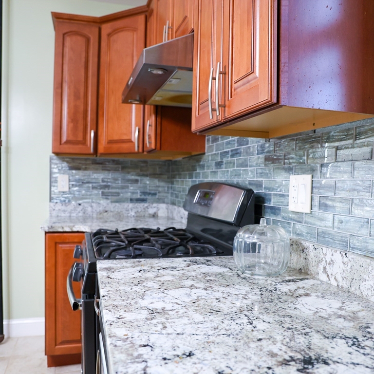 186 Powell Street Lowell, MA 01851 - Photo 20 of 42 a kitchen with a stove and a cabinets