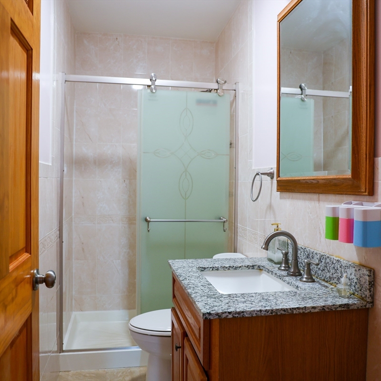 186 Powell Street Lowell, MA 01851 - Photo 22 of 42 a bathroom with a granite countertop sink toilet and shower