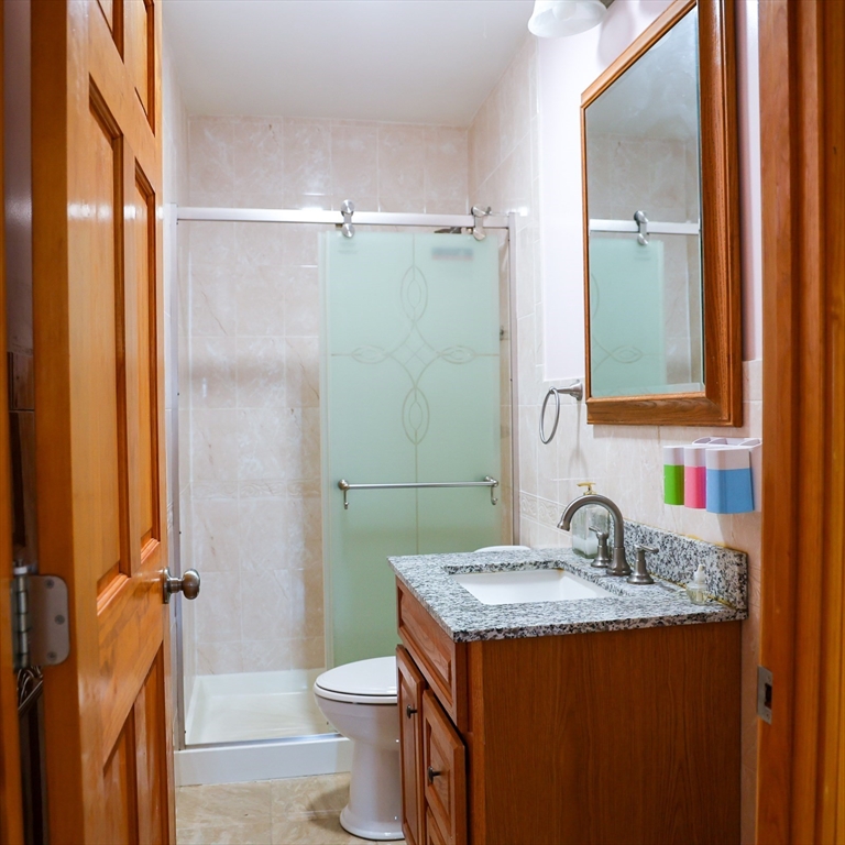 186 Powell Street Lowell, MA 01851 - Photo 23 of 42 a bathroom with a granite countertop sink and a mirror