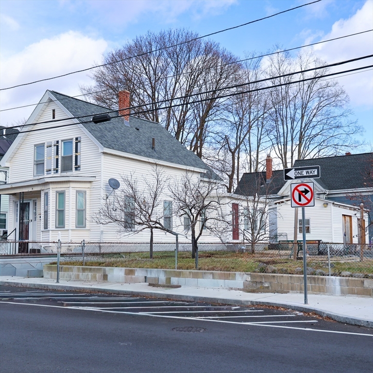 186 Powell Street Lowell, MA 01851 - Photo 3 of 42 a front view of a house with a yard and garage