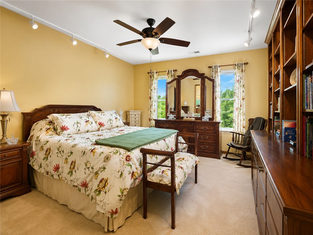 222 Terrace Drive Anderson, SC 29621 - Photo 23 of 37 Sun-filled bedroom featuring a ceiling fan and a wall of built-in bookshelves.