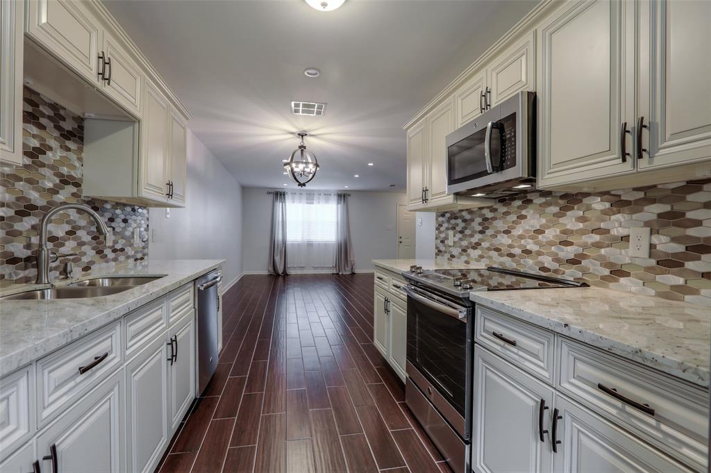 a kitchen with stainless steel appliances granite countertop a sink a stove oven and a granite counter top